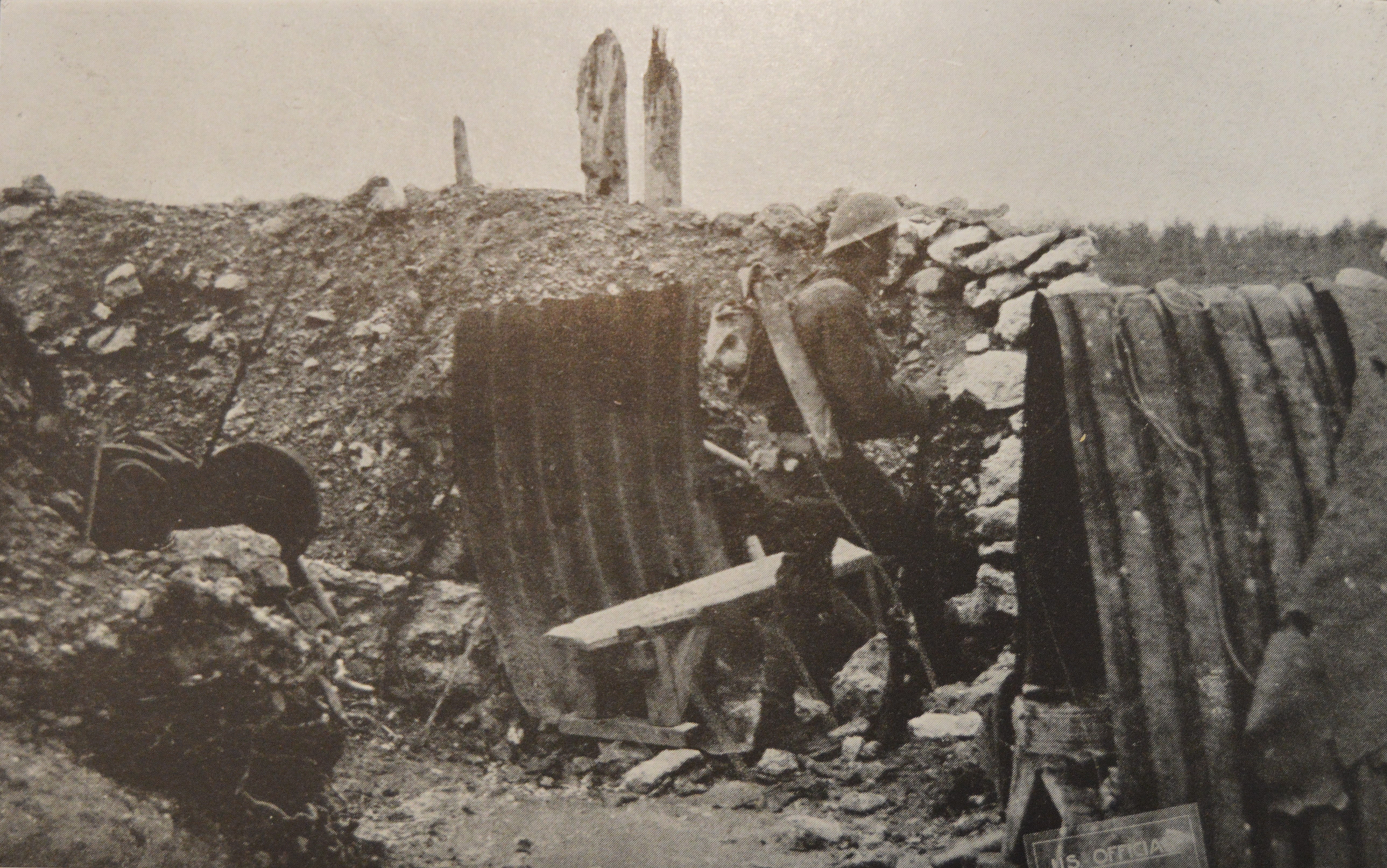 A Soldier from the 103rd Infantry stands over a captured German dugout